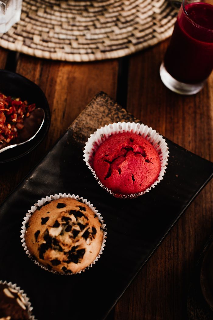pexels photo 6127208 Close-up of red velvet and chocolate muffins on a black plate in a cozy setting.